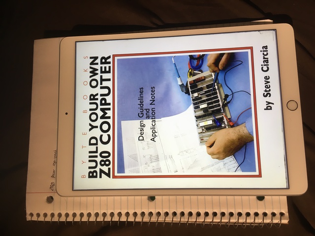 The book 'How to build your own Z80 computer' is displayed on an iPad with a paper notebook in the background.